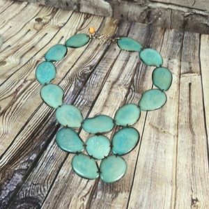 Turquoise colored necklace made from seed pods.